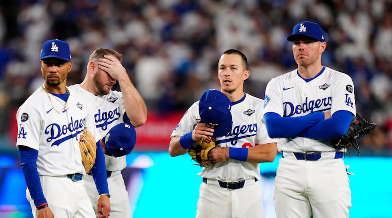 Los Angeles Dodgers shortstop Mookie Betts (50) third baseman Max Muncy (13) second baseman Tommy Edman (25) and first baseman Freddie Freeman (5) look on during a pitching change during seventh inning Game 5 World Series playoff MLB baseball action against the Toronto Blue Jays in Los Angeles on Wednesday, Oct. 29, 2025. (Frank Gunn/The Canadian Press via AP)