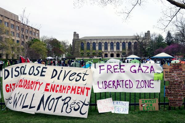FILE - Signs are displayed outside a tent encampment at Northwestern University April 26, 2024, in Evanston, Ill. (AP Photo/Teresa Crawford, File)