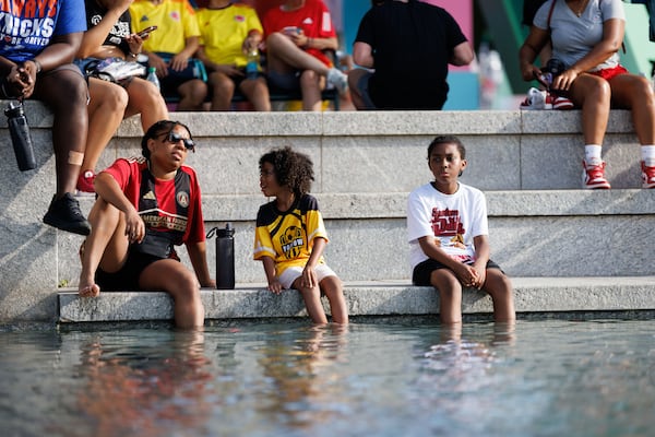 People dip their feet in water to try to beat the heat at the FIFA Fan Fest in Centennial Olympic Park in Atlanta on June 27, 2026. (Estela Muñoz/AJC)