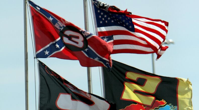 FILE - In this Feb. 15, 2008, file photo, flags, including a Confederate flag, fap in the wind during practice for the NASCAR Sprint Cup Series Daytona 500 auto race at Daytona International Speedway in Daytona Beach, Fla. NASCAR is backing South Carolina Gov. Nikki Haley's call to remove the Confederate flag from the South Carolina Statehouse grounds in the wake of a massacre at a Charleston church, it said in a statement Tuesday, June 23, 2015. Though NASCAR bars the use of the flag in any official capacity, many fans fly the flag at their races. (AP Photo/Darryl Graham, File)