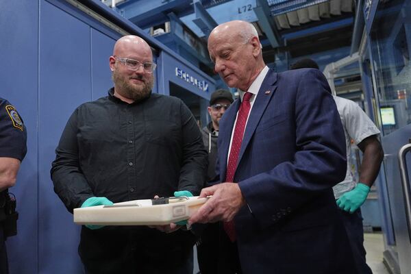 U.S. Treasurer Brandon Beach and Christopher Faulls hold some the last pennies to be pressed at the U.S. Mint in Philadelphia on Wednesday. (Matt Slocum/AP)
