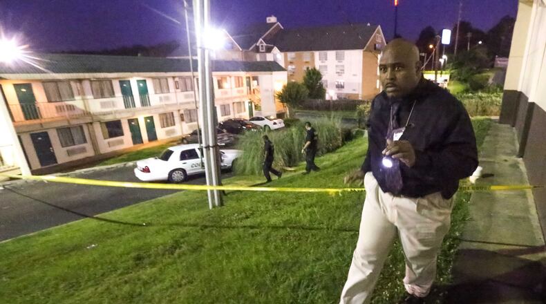 From June 2015: Cobb County police detective M. J. Hill combs the surrounding area of the Masters Inn on Windy Hill Road after a man was shot and killed on the breezeway of the motel.