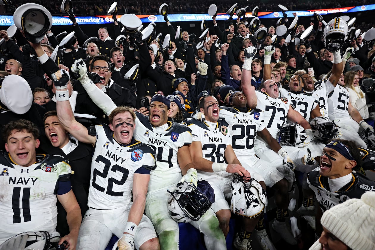 The Navy Midshipmen celebrate after defeating Army 31-13 during the 125th America’s Game at Northwest Stadium on Saturday, Dec. 14, 2024, in Landover, Md. It is a bitter and hard-fought rivalry, but one marked by respect, Ken Sugiura writes. (Patrick Smith/Getty Images/TNS 2024)