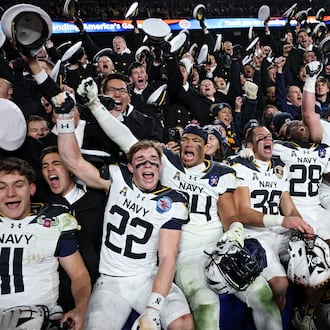 The Navy Midshipmen celebrate after defeating Army 31-13 during the 125th America’s Game at Northwest Stadium on Saturday, Dec. 14, 2024, in Landover, Md. It is a bitter and hard-fought rivalry, but one marked by respect, Ken Sugiura writes. (Patrick Smith/Getty Images/TNS 2024)