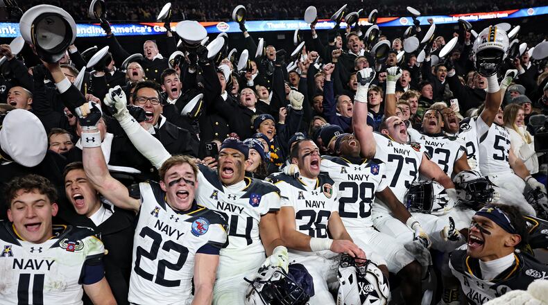 The Navy Midshipmen celebrate after defeating Army 31-13 during the 125th America’s Game at Northwest Stadium on Saturday, Dec. 14, 2024, in Landover, Md. It is a bitter and hard-fought rivalry, but one marked by respect, Ken Sugiura writes. (Patrick Smith/Getty Images/TNS 2024)