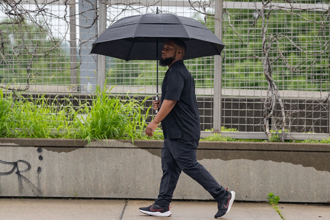 A man walks down 17th Street in the rain in May. Metro Atlanta has had a soggy start to August with a flood watch in effect for Monday, August 4, 2025. (Ben Hendren for the Atlanta Journal-Constitution)