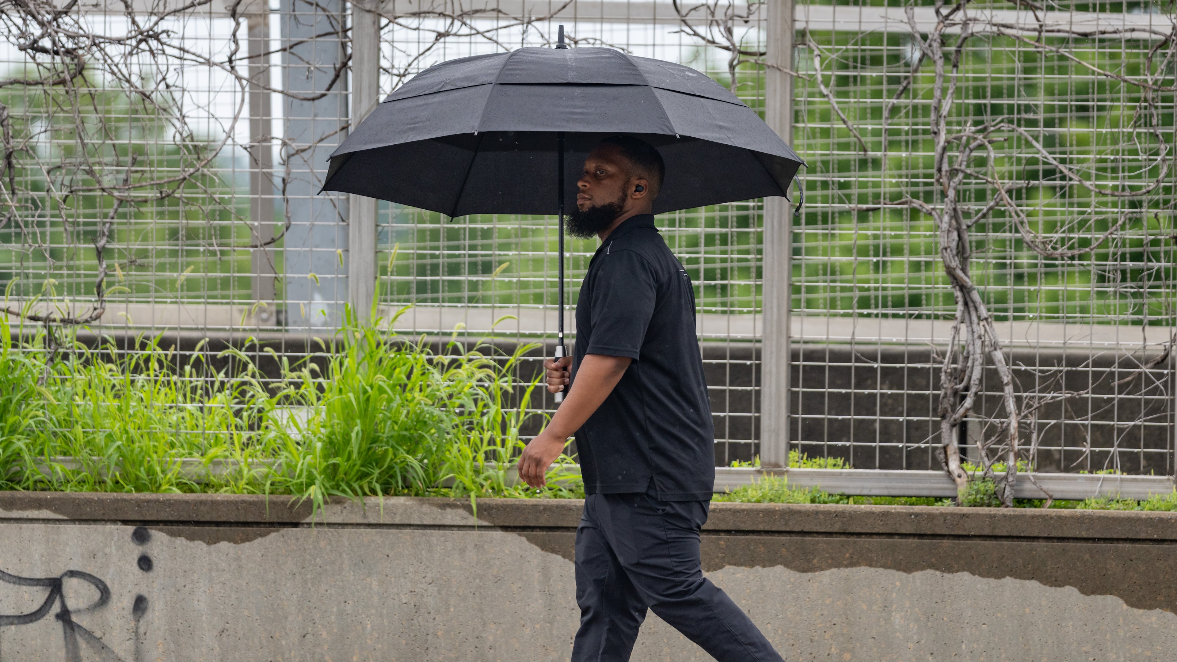 A man walks down 17th Street in the rain on May 29, 2025. After a stormy weekend, more rain is drenching the state Monday, June 9, 2025. (Ben Hendren for the AJC)