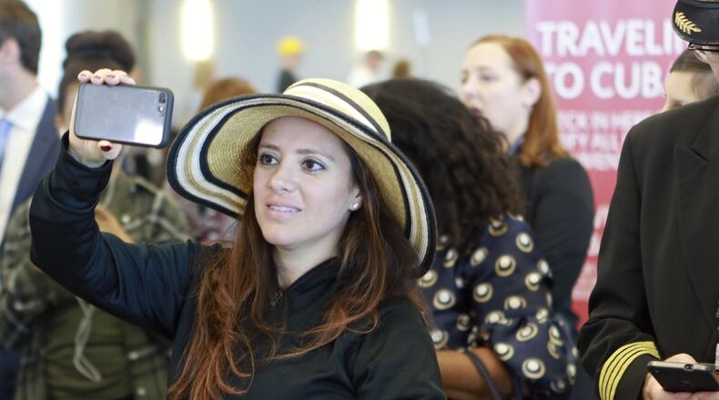Giselle Golden, of Atlanta, takes photos as she waits to board Delta’s inaugural Atlanta-Havana flight. Delta launched scheduled service from three U.S. cities on Thursday, amid a wave of new U.S.-Cuba flights. BOB ANDRES /BANDRES@AJC.COM