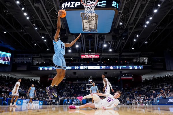 American University forward Matt Rogers (15) reacts to an injury as Mount St. Mary's forward Jedy Cordilia (14) shoots during the first half of a First Four college basketball game in the NCAA Tournament, Wednesday, March 19, 2025, in Dayton, Ohio. (AP Photo/Jeff Dean)