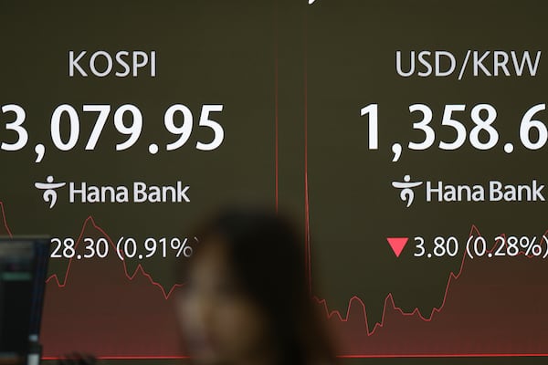 A dealer talks near the screens showing the Korea Composite Stock Price Index (KOSPI), left, and the foreign exchange rate between U.S. dollar and South Korean won at a dealing room of Hana Bank in Seoul, South Korea, Thursday, June 26, 2025. (AP Photo/Lee Jin-man)