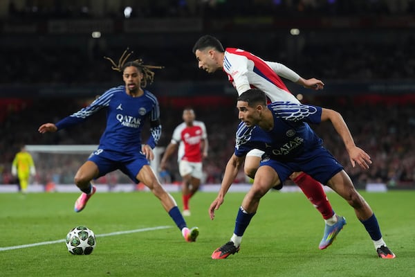Arsenal's Gabriel Martinelli, center, is tackled by PSG's Achraf Hakimi during the Champions League semifinal first leg soccer match between Arsenal and Paris Saint-Germain at Emirates Stadium in London, England, Tuesday, April 29, 2025. (AP Photo/Kirsty Wigglesworth)