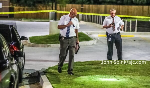 The restaurant's parking lot is blocked off with crime tape as DeKalb detectives collect shell casings and other evidence from the scene.