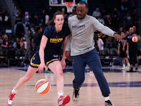 Indiana Fever guard Caitlin Clark, left, warms up before a WNBA basketball game against the Golden State Valkyries in San Francisco, Thursday, June 19, 2025. (Anna Connors/San Francisco Chronicle via AP)