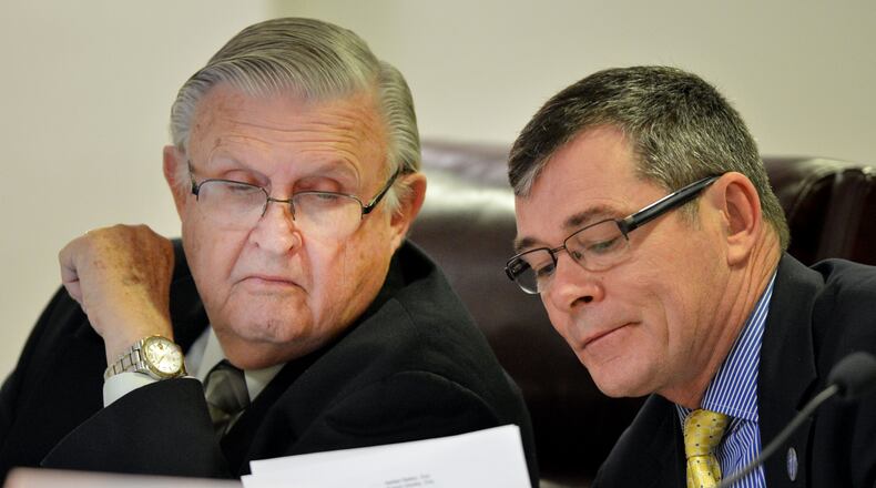 Commissioners Doug Everett (left) and Tim Echols talk during a 2013 Public Service Commission hearing. KENT D. JOHNSON / KDJOHNSON@AJC.COM