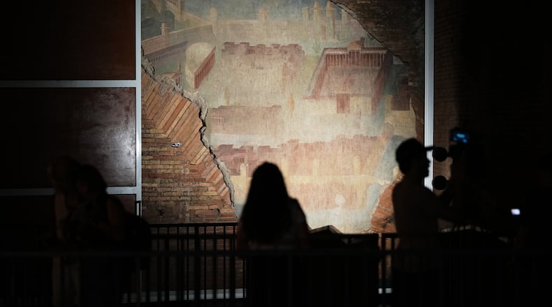 Reporters film the "The Painted City" fresco, discovered during 1990s built as foundations for the Baths of Trajan that has been restored, in Rome, Tuesday, Sept. 8, 2026.(AP Photo/Andrew Medichini)