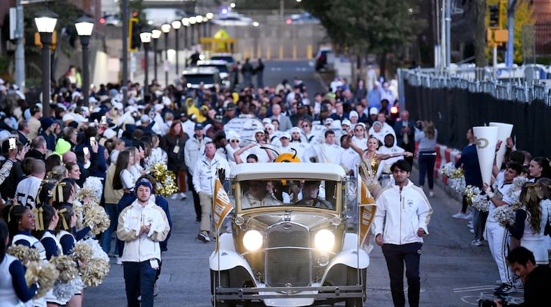 Georgia Tech's Ramblin' Wreck leads the band, cheerleaders, Buzz, players, and coaches walk down Yellow Jacket Alley prior to an NCAA college football game between Georgia Tech and North Carolina State at Bobby Dodd Stadium, Thursday, November 21, 2024, in Atlanta. (Hyosub Shin / AJC)
