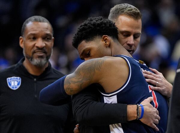Arizona guard Caleb Love (1) hugs Duke head coach Jon Scheyer after Arizona lost to Duke in a Sweet 16 round NCAA college basketball tournament game, Friday, March 28, 2025, in Newark, N.J. (AP Photo/Julia Demaree Nikhinson)