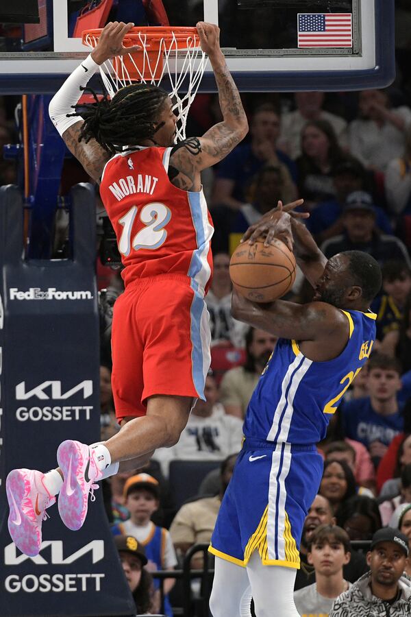 Memphis Grizzlies guard Ja Morant (12) and Golden State Warriors forward Draymond Green (23) move for position in the first half of an NBA basketball game Tuesday, April 1, 2025, in Memphis, Tenn. (AP Photo/Brandon Dill)