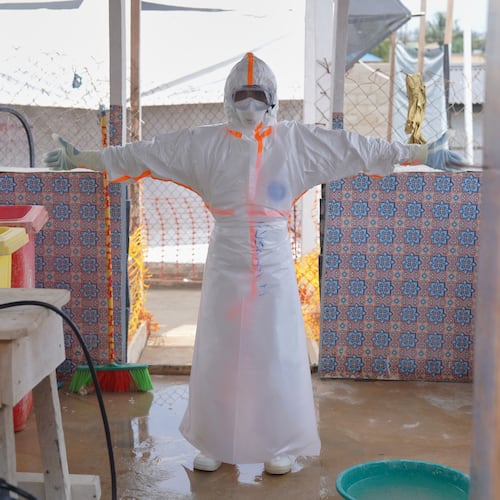 A health worker waits to be sprayed with disinfectant at the treatment centre in Bunia General Hospital in Ituri, eastern Congo, Tuesday, Aug. 11, 2026. (AP Photo/Dieudonne Dirole)