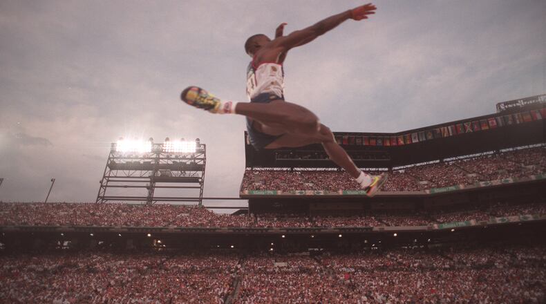 American Carl Lewis soars into first place during the long jump competition of the 1996 Atlanta Olympics on July 29, 1996, at Olympic Stadium in Atlanta. (Rich Addicks/AJC 1996)
