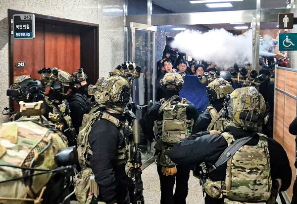 FILE - National Assembly staff spray fire extinguishers in an effort to block soldiers from entering the main hall of the legislature in Seoul, South Korea, on Dec. 4, 2024. (Jo Da-un/Yonhap via AP, File)