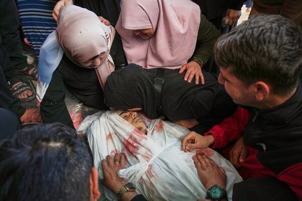 Relatives mourn over the body of Abdullah Habbash before his funeral, along with the bodies of six brothers from the Abu Mahadi family, all members of a Palestinian charity organization linked to Hamas, who were killed earlier in an Israeli army strike on the car they were traveling in, in Deir al-Balah, central Gaza Strip, Sunday, April 13, 2025. (AP Photo/Abdel Kareem Hana)"