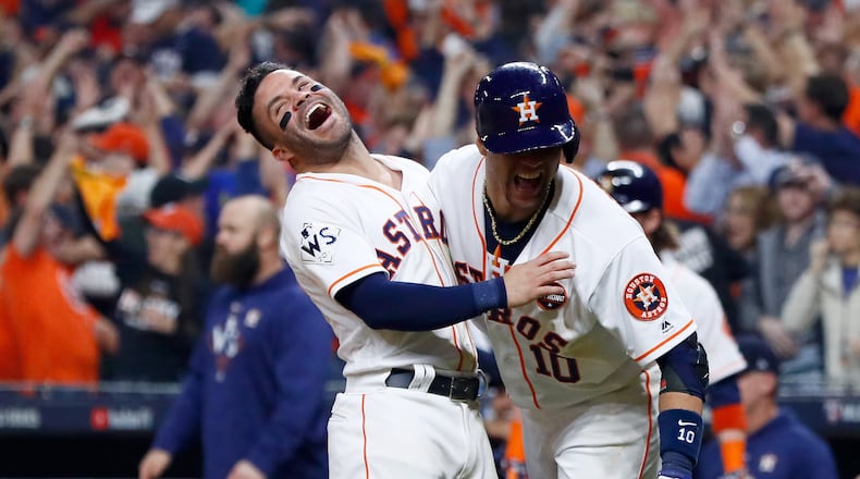 Jose Altuve #27 and Yuli Gurriel #10 of the Houston Astros celebrate after a two-run home run by Carlos Correa in game five of the 2017 World Series against the Los Angeles Dodgers.