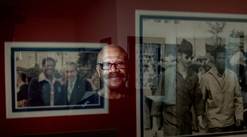Former POW Lt. Col. James W. Williams, in Norcross this month, is reflected in a framed photo of himself with President Richard Nixon, left, and a photo of him being escorted as a prisoner of war. Willams was shot down while flying a F-4D Phantom during a mission over North Vietnam. BRANDEN CAMP/SPECIAL