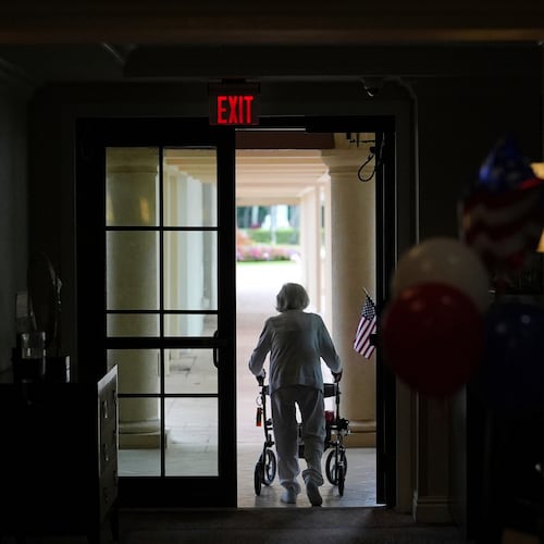 FILE - A woman uses a walker as she exits an assisted living building, July 4, 2025, in Boca Raton, Fla. (AP Photo/Rebecca Blackwell, File)