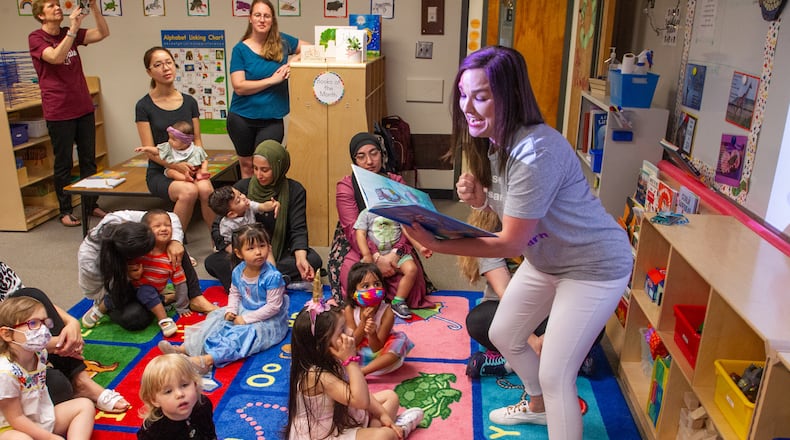 Teacher Emily Broich reads aloud to her kids and their mothers at B.B. Harris Elementary school in Duluth Friday May 13, 2022. (Steve Schaefer / steve.schaefer@ajc.com)