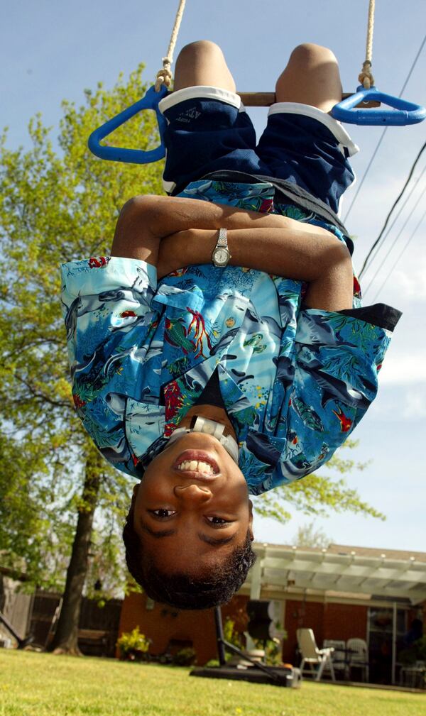 FILE - Nine-year-old P.J. Allen plays in his backyard in Oklahoma City on April 17, 2003. One of the youngest survivors of the Oklahoma City bombing, Allen says he wants more than anything to be able to swim and wrestle with his friends without worrying about the tracheotomy in his throat getting dislodged. (AP Photo/Sue Ogrocki, File)