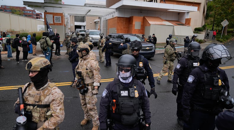 FILE - Law enforcement officers stand in the street to allow vehicles to leave a U.S. Immigration and Customs Enforcement facility during a protest in Portland, Ore., Oct. 11, 2025. (AP Photo/Jenny Kane, File)