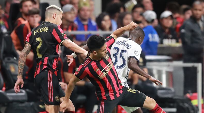 October 24, 2019 Atlanta: Atlanta United players Franco Escobar (left) and Pity Martinez drive around Philadelphia defender Jamiro Monteiro in the Eastern Conference semifinals of the MLS playoffs on Thursday, October 24, 2019, in Atlanta.   Curtis Compton/ccompton@ajc.com