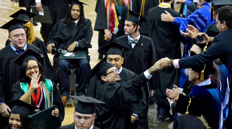 Georgia Gwinnett College’s 2,000th graduate Angelo Cifuentes (center) receives a congratulatory fist bump from his brother during the recessional; courtesy of Georgia Gwinnett College