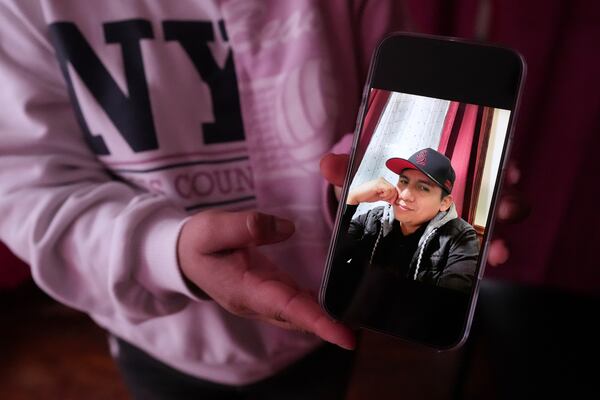Marilu Domingo Ortiz, whose husband was taken into custody by ICE agents after they smashed a window of their family car, shows a photograph of her spouse, Juan Francisco Mendez, at their home, Wednesday, April 16, 2025, in New Bedford, Mass. (AP Photo/Charles Krupa)