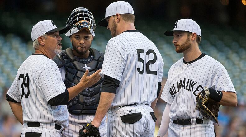 Jimmy Nelson #52 of the Milwaukee Brewers talks with pitching coach Rick Kranitz #39, Martin Maldonado #12, and Jonathan Lucroy #20 after a rough first inning against the Pittsburgh Pirates at Miller Park on July 18, 2015 in Milwaukee, Wisconsin. (Photo by Tom Lynn/Getty Images)