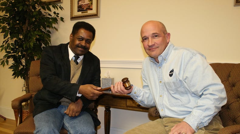 Dr. Carlo Musso (right), shown here handing over the gavel as chairman of the Housing Authority of Clayton County to his successor, James Searcy, is CEO of CorrectHealth. (Chris Wood / Special)