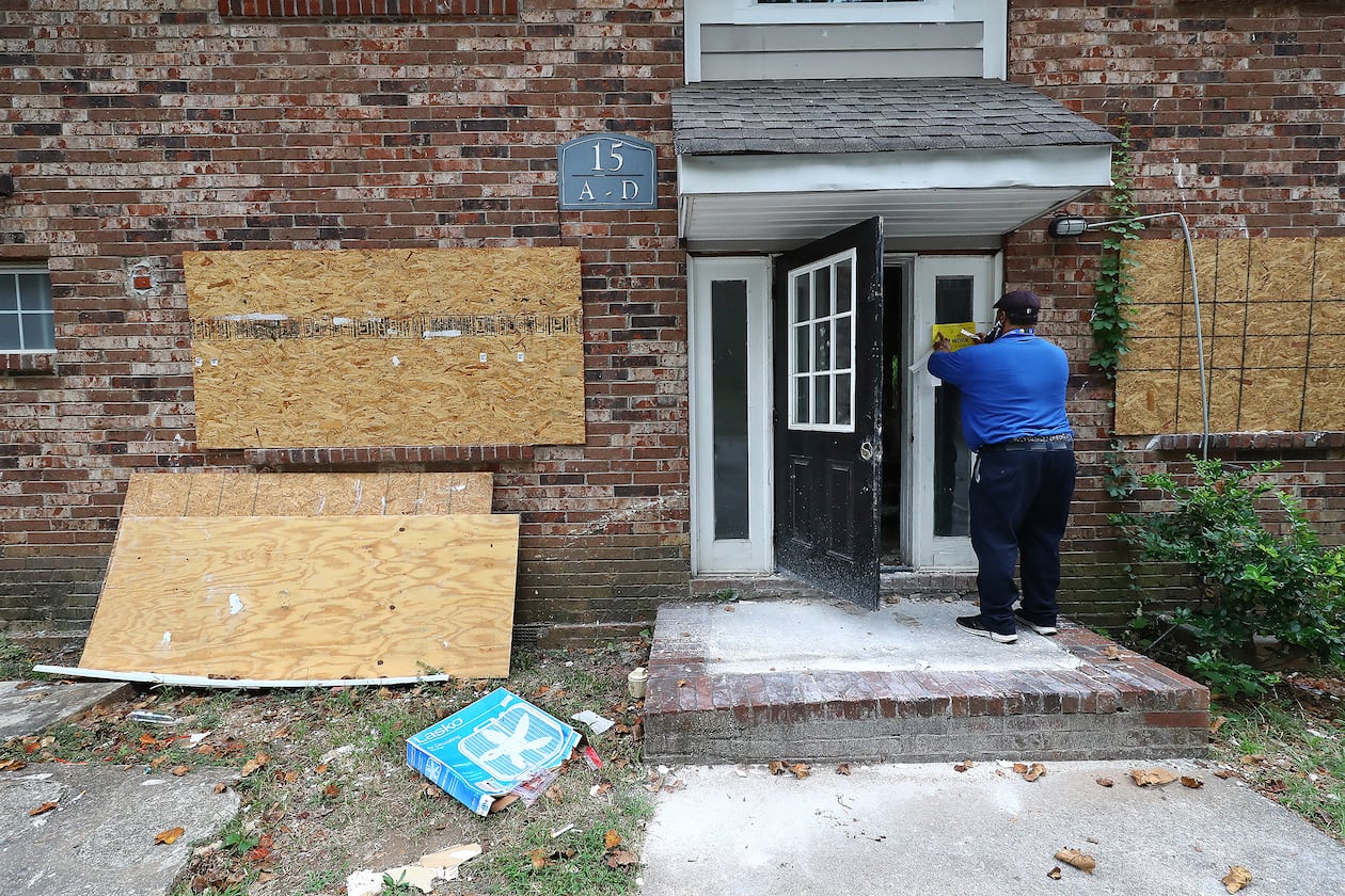 An Atlanta code enforcement officer posts a stop-work order on a burned-out unit at Pavilion Place, an aging, derelict apartment complex on south of downtown. Curtis Compton / Curtis Compton@ajc.com