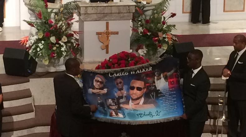 Ushers display a prayer shawl before presenting it to Shawty Lo's mother at the Saturday funeral service. Photo: Jennifer Brett