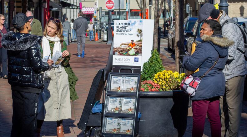 FILE - A woman shares Jehovah's Witnesses' literature with a passerby in downtown Pittsburgh on Nov. 13, 2023. (AP Photo/Peter Smith, File)