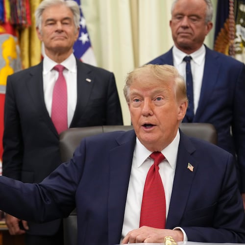 President Donald Trump holds up a printout of a Breitbart article as Arkansas Gov. Sarah Huckabee Sanders, from left, Mehmet Oz, administrator of the Centers for Medicare & Medicaid Services, and Health and Human Services Secretary Robert F. Kennedy Jr., look on during an event about healthcare in the Oval Office of the White House, Friday Sept. 18, 2026, in Washington. (AP Photo/Jacquelyn Martin)