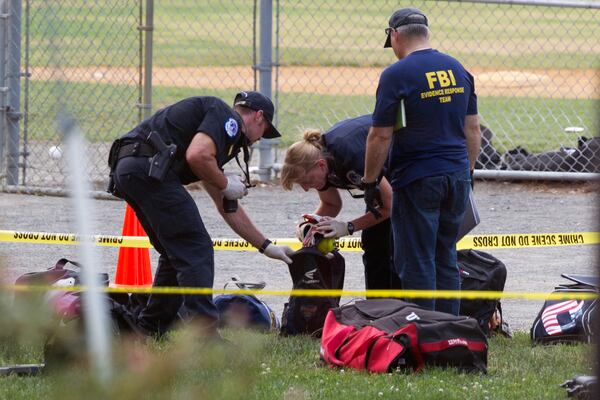 FILE - An FBI Evidence Response team inspects the contents of one of the many bags left at the scene of a shooting in Alexandria, Va., Wednesday, June 14, 2017, involving House Majority Whip Steve Scalise of La., and others, during a congressional baseball practice. (AP Photo/Cliff Owen, file)