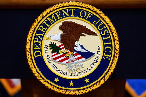 FILE - The U.S. Department of Justice logo is seen on a podium before a press conference with Attorney General Pam Bondi, Tuesday, May 6, 2025, at the Justice Department in Washington. (AP Photo/Julia Demaree Nikhinson, file)