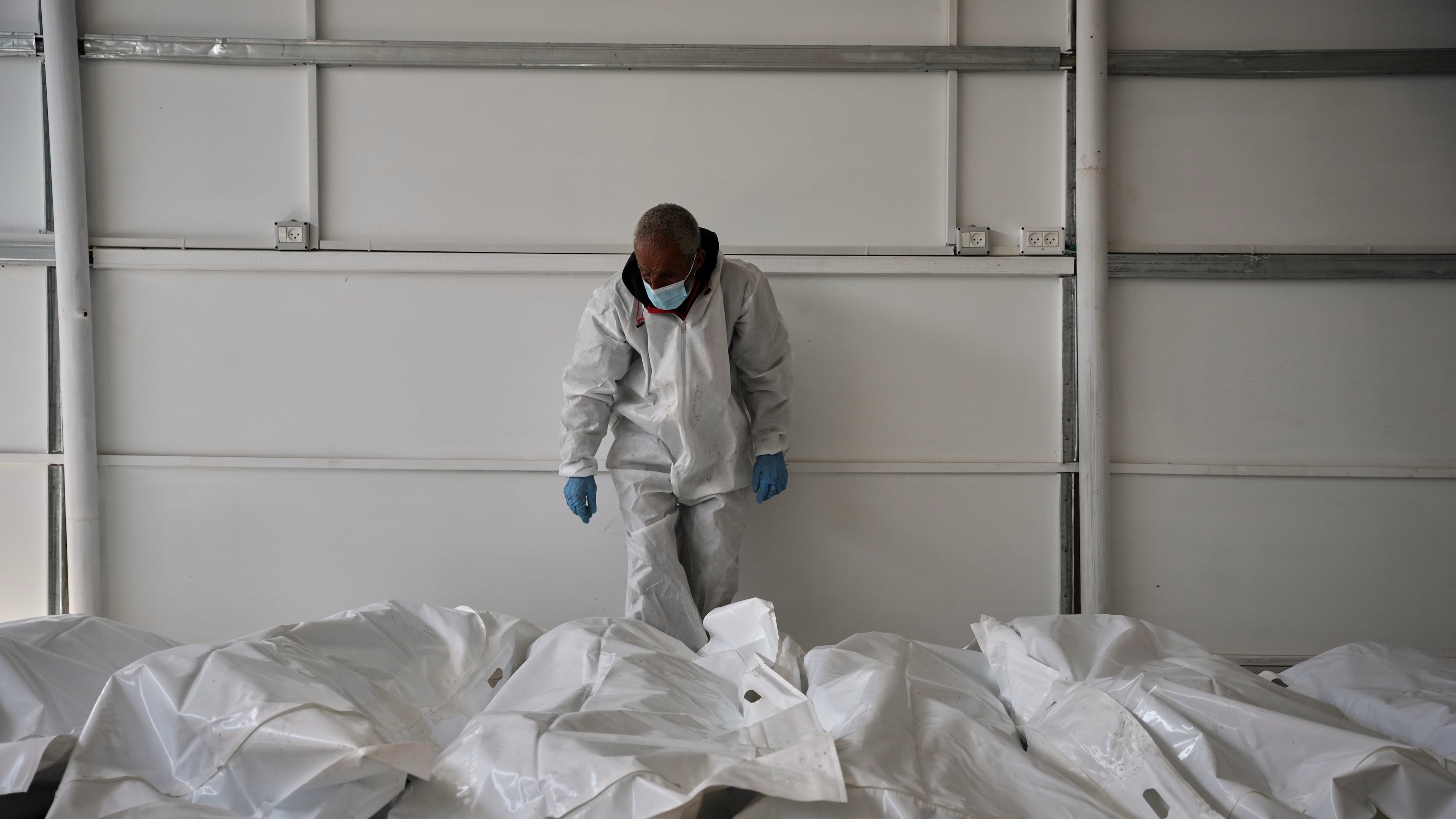 Bodies of unidentified Palestinians returned from Israel as part of the ceasefire deal are placed at a warehouse in Nasser Hospital in Khan Younis, Gaza Strip, Friday, Oct. 31, 2025. (AP Photo/Abdel Kareem Hana)