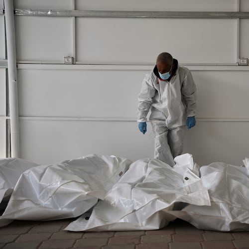Bodies of unidentified Palestinians returned from Israel as part of the ceasefire deal are placed at a warehouse in Nasser Hospital in Khan Younis, Gaza Strip, Friday, Oct. 31, 2025. (AP Photo/Abdel Kareem Hana)