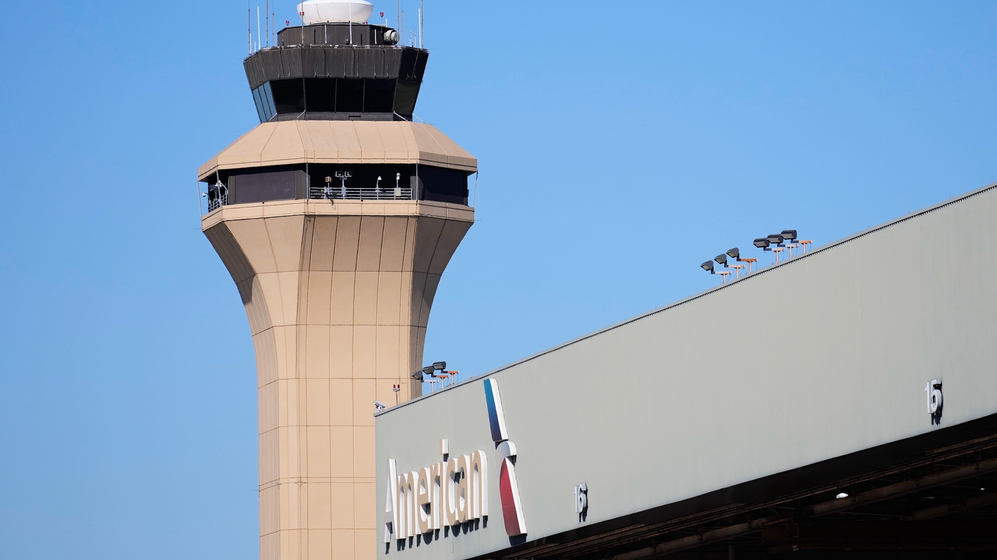 FILE - A control tower by an American Airlines hangar is shown at Dallas Fort Worth International Airport, Oct. 15, 2025, in DFW Airport, Texas. (AP Photo/Tony Gutierrez, file)