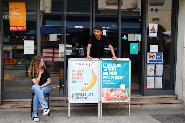 Supermarket workers stand outside a closed shop due to a electricity outage in Cannes, southern France, Saturday, May 24, 2025. (AP Photo/Natacha Pisarenko)