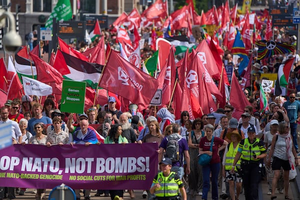 People carry banners and flags during a demonstration ahead of the NATO summit in The Hague, Netherlands, Sunday, June 22, 2025. (AP Photo/Peter Dejong)