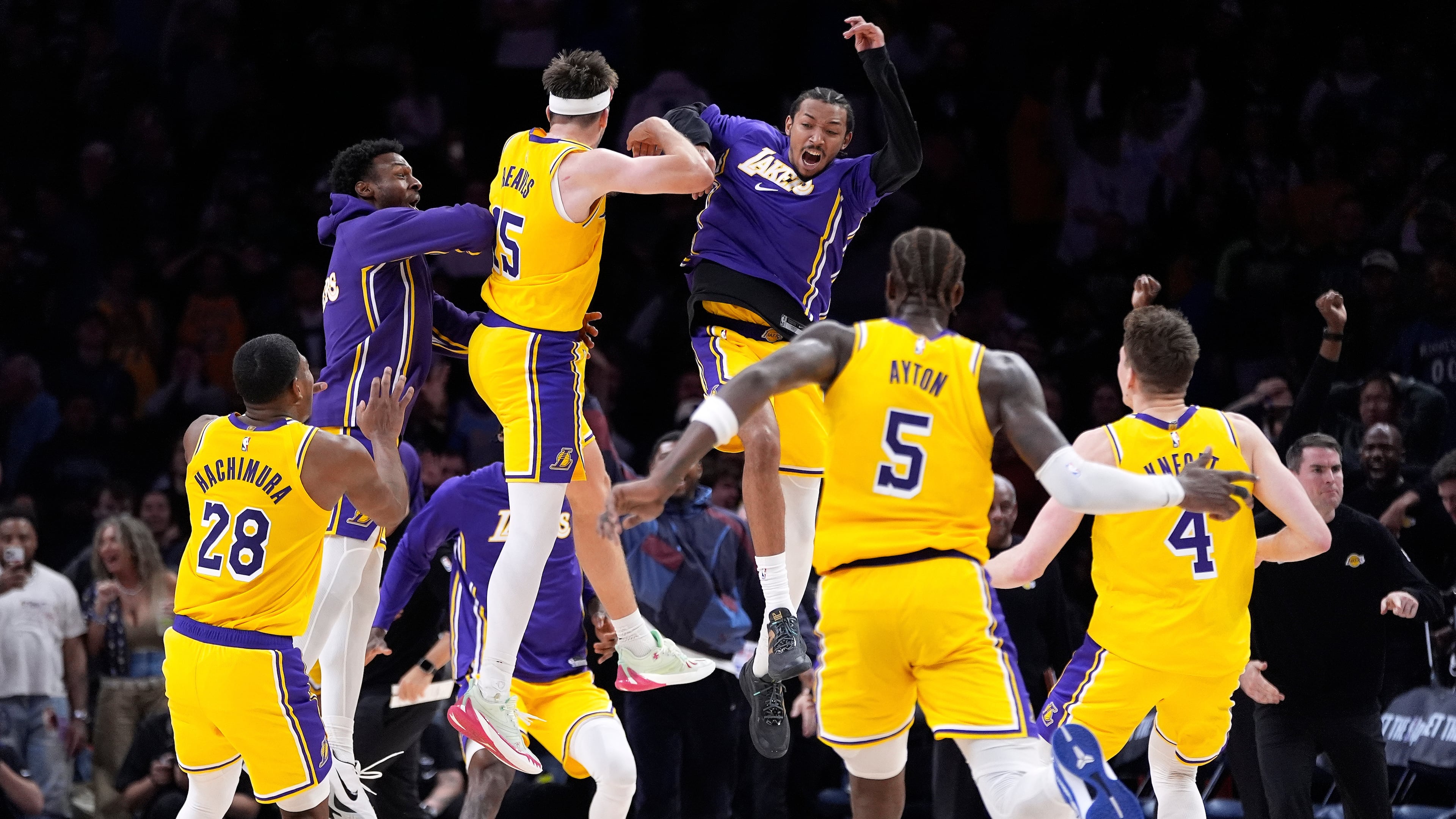 Los Angeles Lakers guard Austin Reaves (15) celebrates with teammates after making the game-winning shot at the buzzer in an NBA basketball game against the Minnesota Timberwolves, Wednesday, Oct. 29, 2025, in Minneapolis. (AP Photo/Abbie Parr)