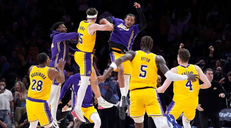Los Angeles Lakers guard Austin Reaves (15) celebrates with teammates after making the game-winning shot at the buzzer in an NBA basketball game against the Minnesota Timberwolves, Wednesday, Oct. 29, 2025, in Minneapolis. (AP Photo/Abbie Parr)